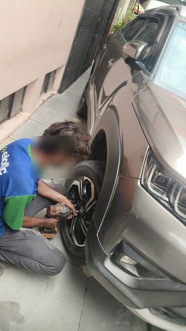 OnRoads India technician changing a flat tyre on an SUV with a power wrench