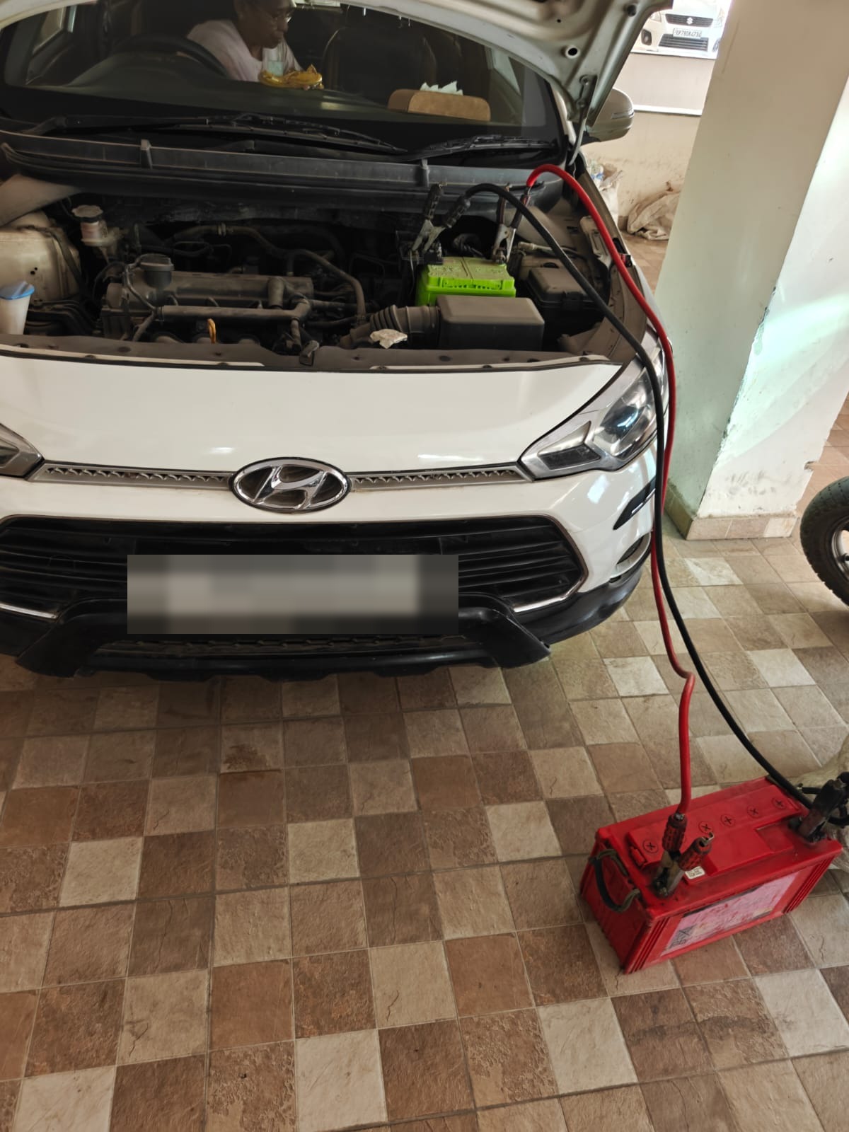 Technician jump starting a Hyundai i20 during OnRoads India roadside assistance