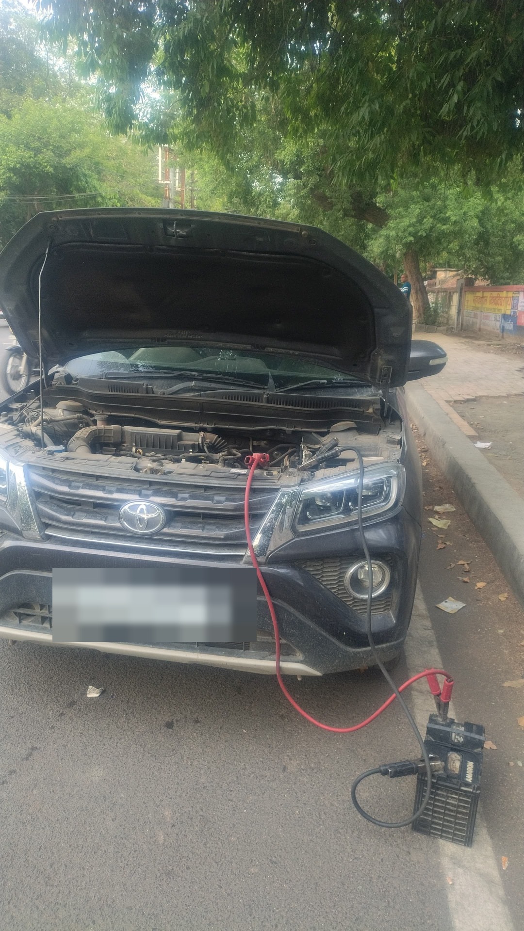 Toyota Fortuner receiving a roadside battery jump start from OnRoads India